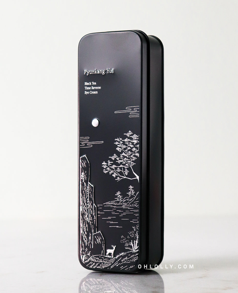 Front-on studio shot of the black Pyunkang Yul Black Tea Time Reverse Eye Cream outer box. The box features an elegant white illustration of a deer, moon, and landscape, emphasizing the product's premium, anti-aging, and skin-strengthening focus.