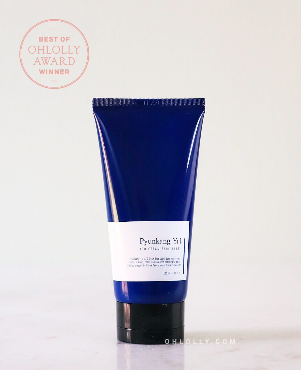 Studio shot of the Pyunkang Yul ATO Cream Blue Label tube standing on a pale background. A 'BEST OF OHLOLLY AWARD WINNER' stamp graphic is visible in the top left corner, highlighting the product's quality and popularity.