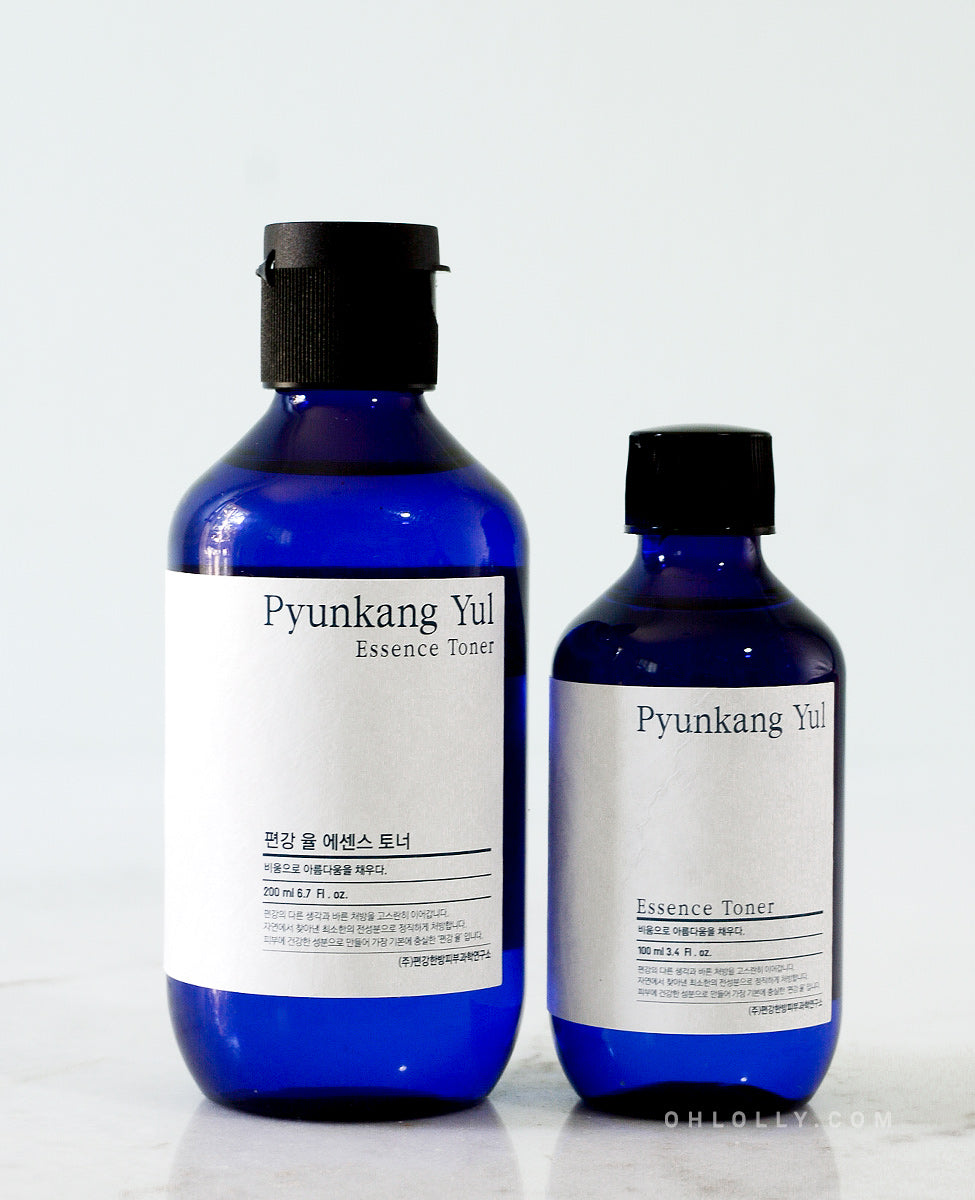 Side-by-side product shot of two sizes (200 ml and 100 ml) of the Pyunkang Yul Essence Toner. Both bottles are dark blue glass with black caps, standing against a light background.