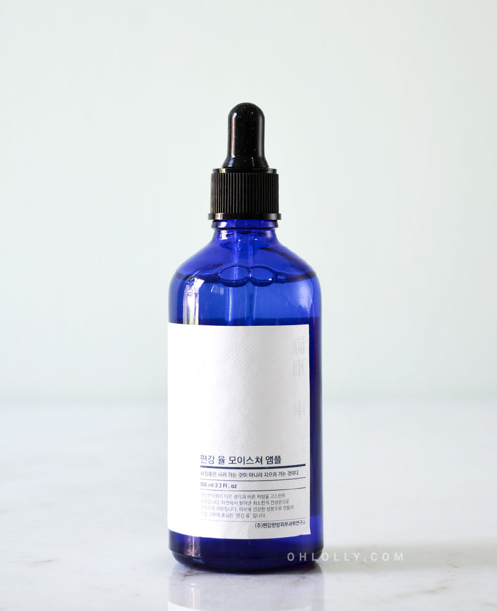Close-up, detailed shot of the Pyunkang Yul Moisture Ampoule's dark blue glass jar and simple white rectangular label, focusing on the product name.
