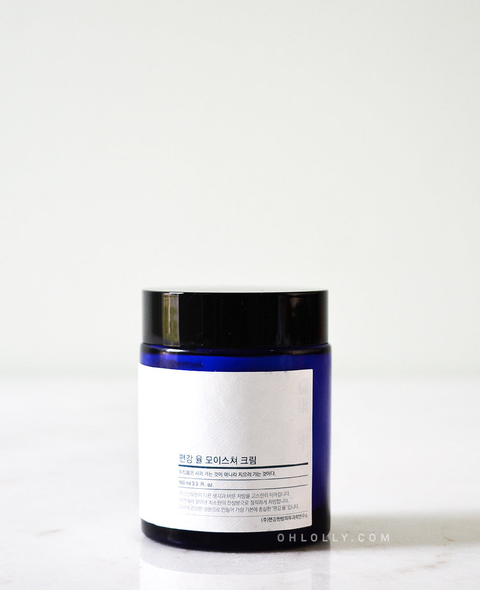 Straight-on, detailed shot of the Pyunkang Yul Moisture Cream's dark blue glass jar, focusing on the product name and the simple, clean design of the white label.