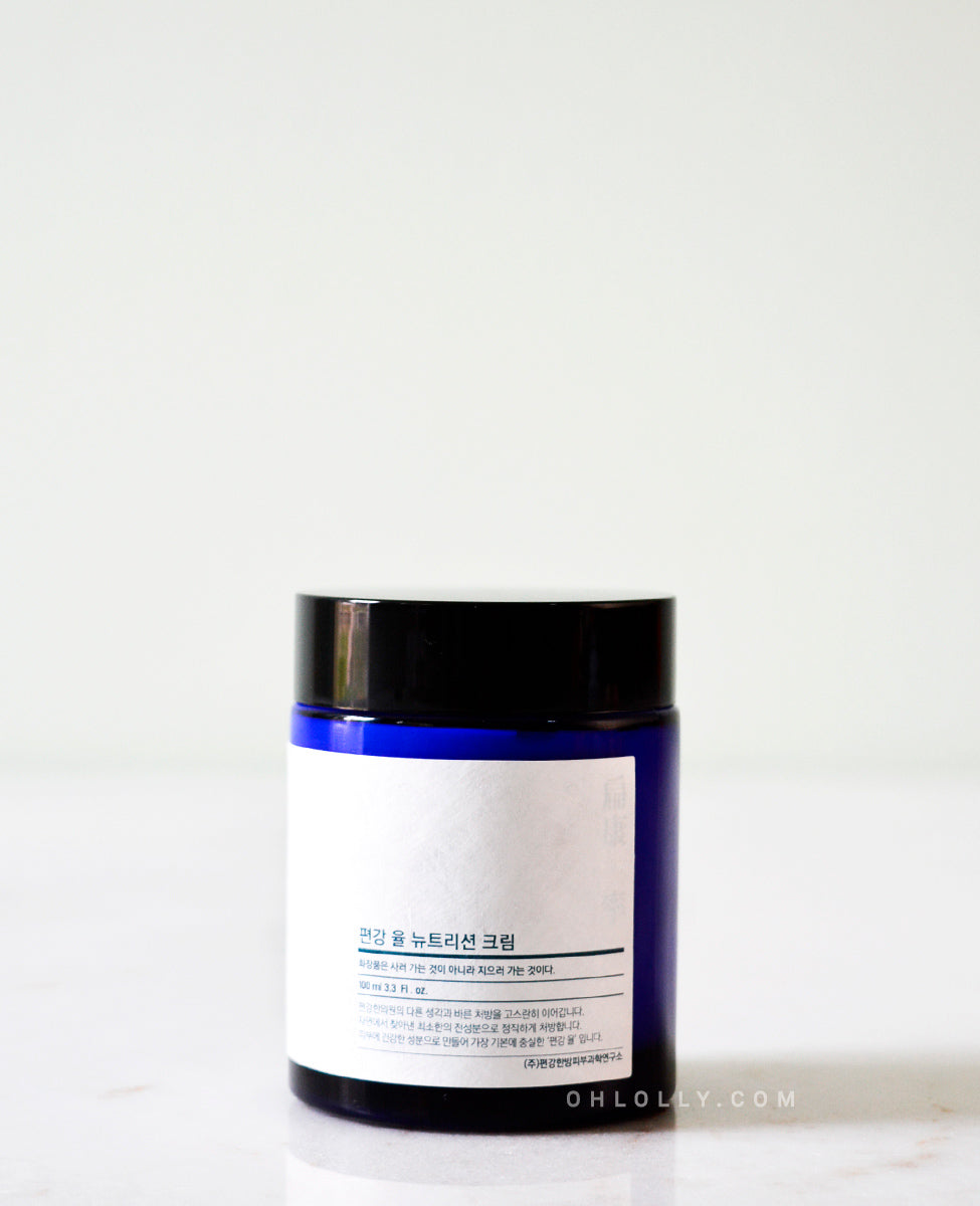 Close-up, straight-on shot of the Pyunkang Yul Nutrition Cream's dark blue glass jar, focusing on the white rectangular label and the product name.