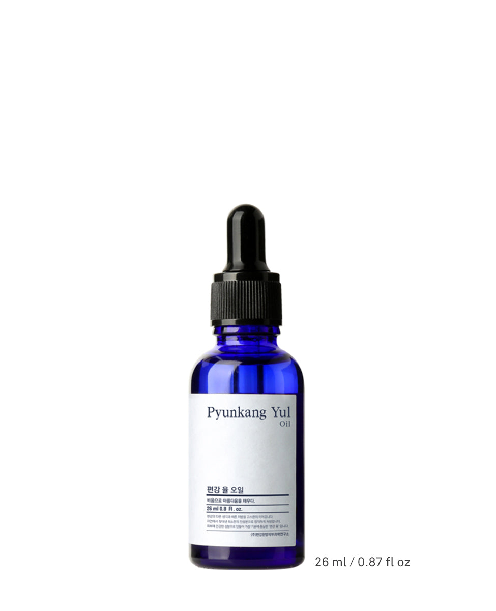 Studio shot of the Pyunkang Yul Oil in its dark blue glass dropper bottle with a black cap, standing on a white surface with the text '26 ml / 0.87 fl oz' visible at the bottom right.