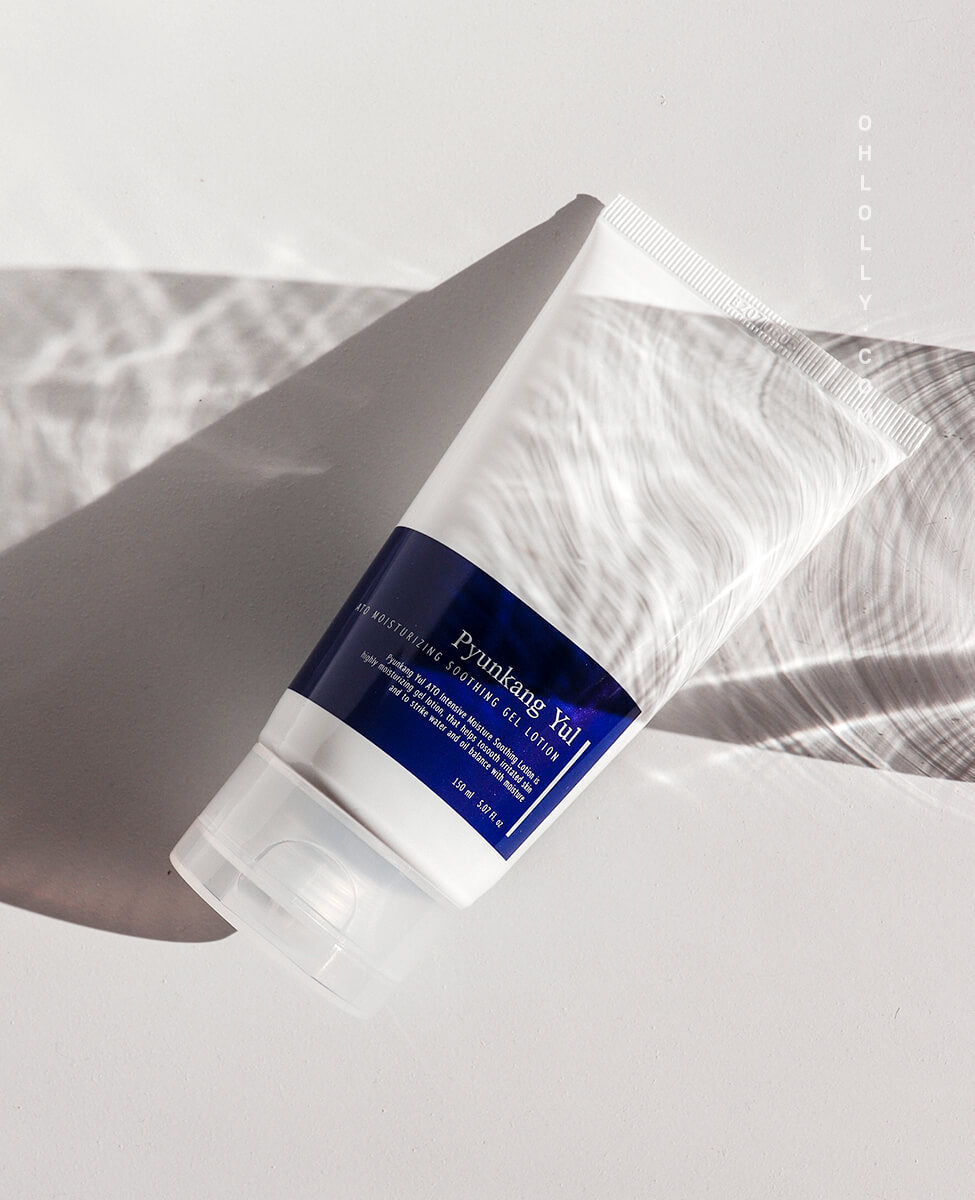 Studio shot of the Pyunkang Yul ATO Moisturizing Soothing Gel Lotion tube lying diagonally on a pale surface. Dramatic side lighting highlights the tube's curve and creates strong shadows, emphasizing the product's clean aesthetic and simple packaging.