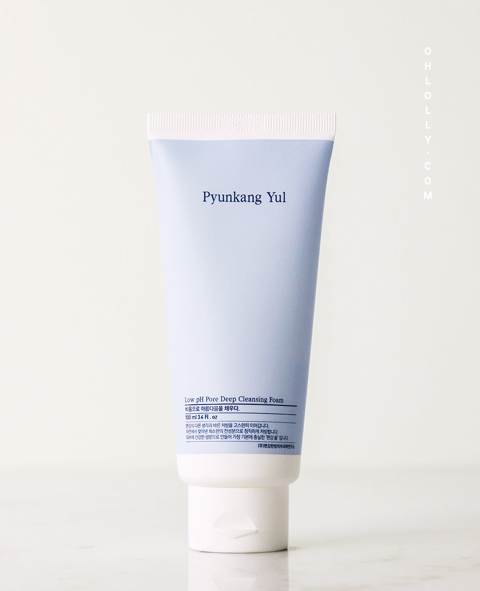 Close-up, straight-on studio shot of the Pyunkang Yul Low pH Pore Deep Cleansing Foam tube, standing upright on a pale gray background. The light blue and white tube clearly displays the Pyunkang Yul logo and the product name on the front label, emphasizing its low pH formula.