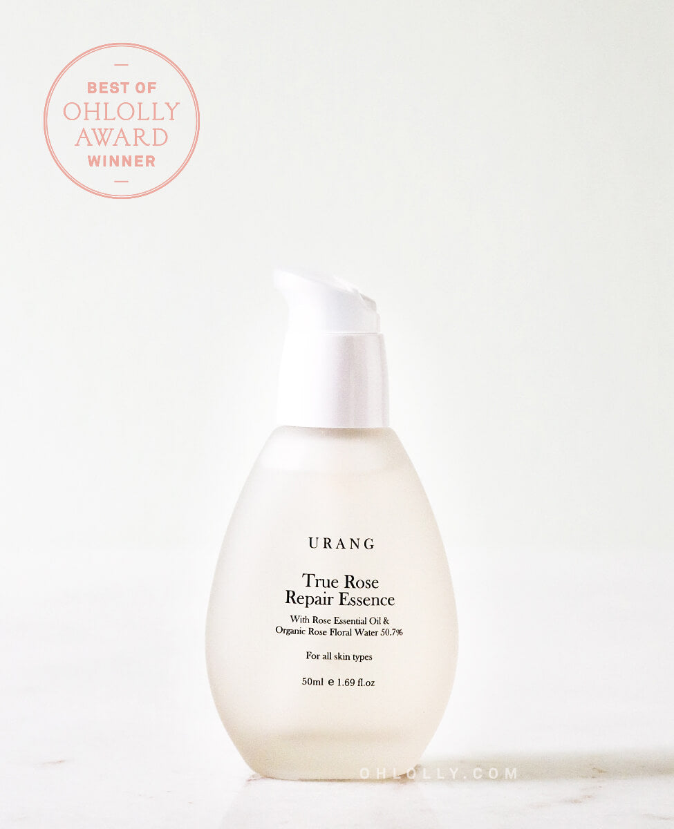 The Urang True Rose Repair Essence in a clear, frosted glass pump bottle with a white lid, featuring a pink "Best of Ohlolly Award Winner" seal in the top corner.
