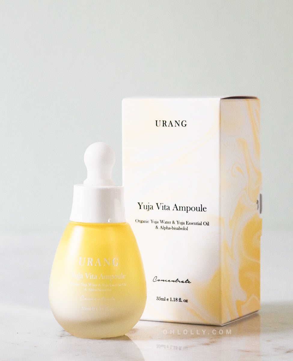 The Urang Yuja Vita Ampoule: a small, frosted glass dropper bottle with a milky-yellow serum inside, displayed next to its matching white and yellow product box.