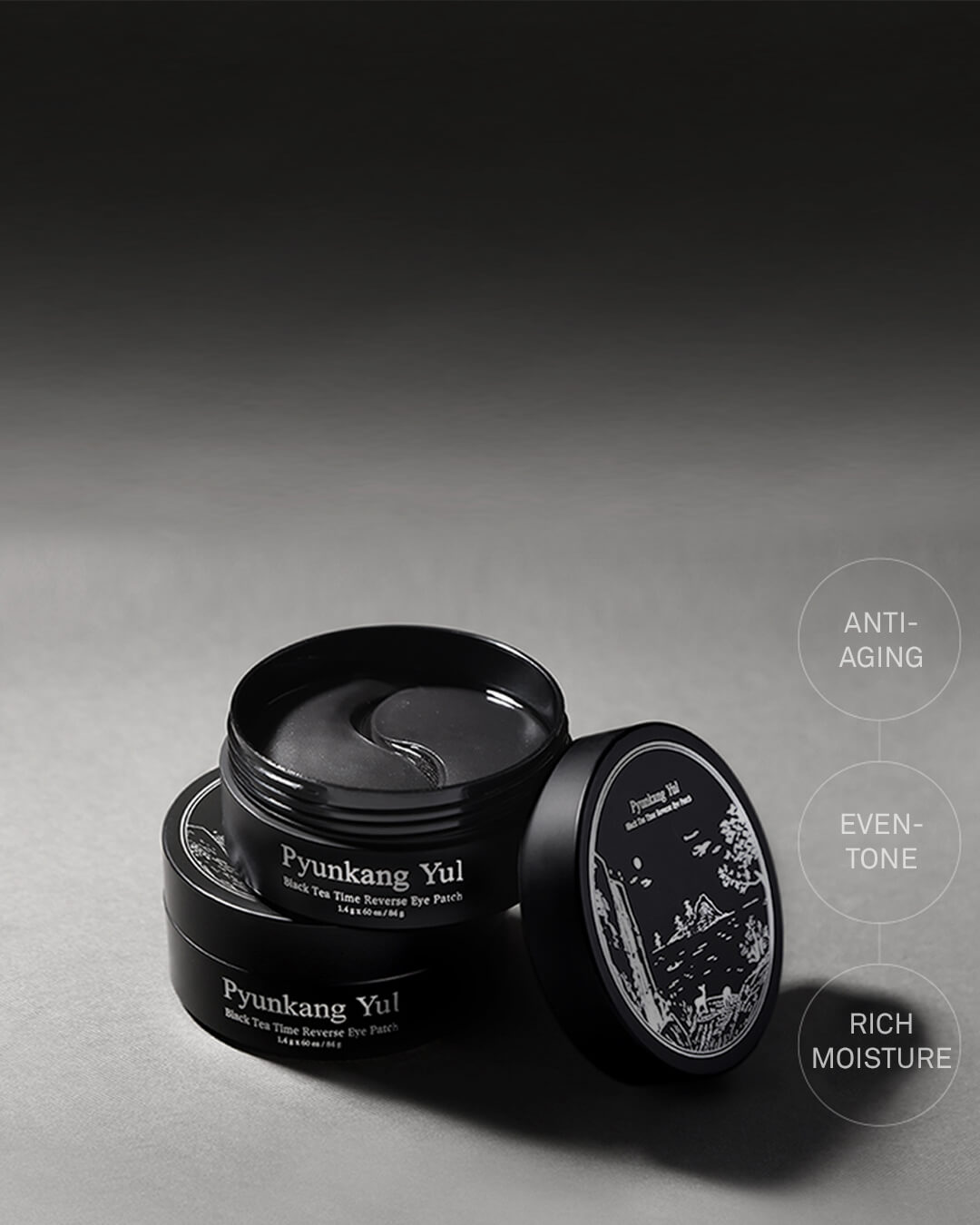 Angled studio shot of the open black Pyunkang Yul Black Tea Time Reverse Eye Patch jar, showing the dark, crescent-shaped hydrogel patches inside. Text overlays highlight the key benefits: Anti-Aging, Even-Tone, and Rich Moisture.
