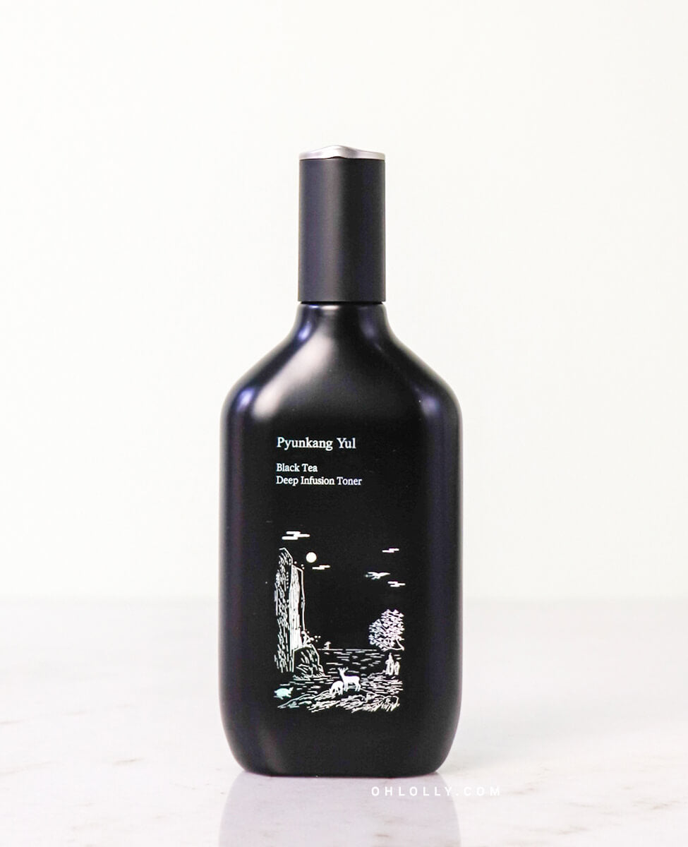 Front-on studio shot of the black Pyunkang Yul Black Tea Deep Infusion Toner bottle, highlighting the white waterfall illustration. The bottle stands alone on a light surface, emphasizing the product's premium and minimalist anti-aging design.
