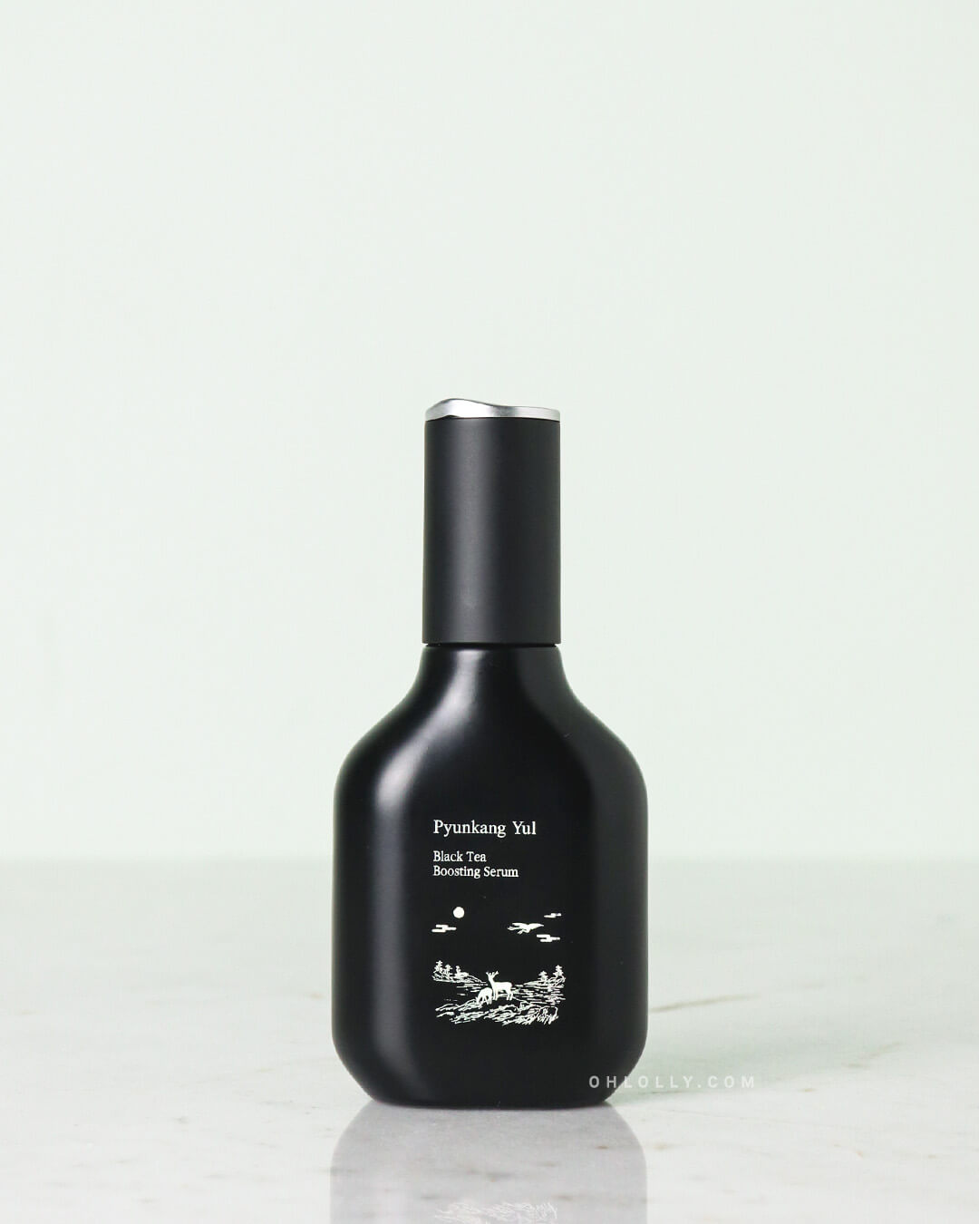 Front-on studio shot of the Pyunkang Yul Black Tea Boosting Serum dark blue glass bottle and its matching outer box, emphasizing the product's premium packaging and anti-aging benefits with black tea extract.