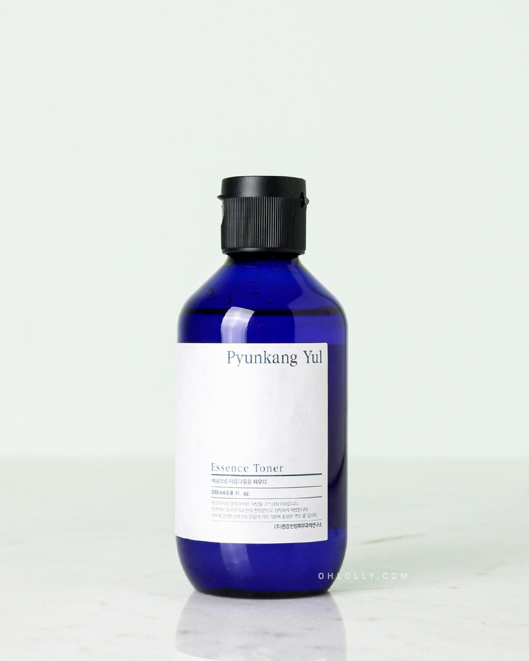 Studio shot of the Pyunkang Yul Essence Toner, showing the dark blue glass 200ml bottle with a black cap against a light, neutral background.
