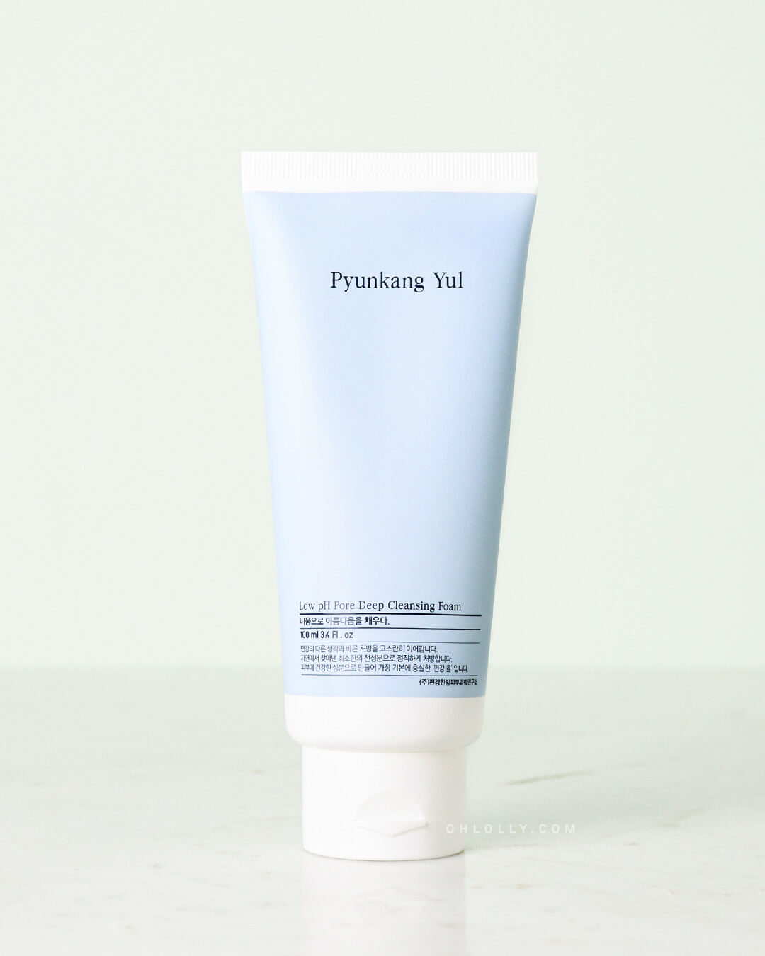 Studio shot of the Pyunkang Yul Low pH Pore Deep Cleansing Foam tube, standing upright. The soft, light blue tube has a white, flip-top cap and a simple white label displaying the product name, all against a pale, neutral background.