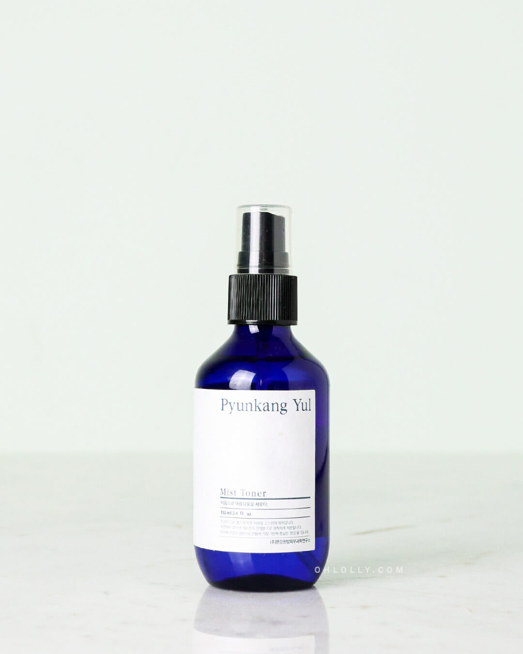 Studio shot of the 100 ml Pyunkang Yul Mist Toner in a dark blue spray bottle with a black cap, standing on a white surface.