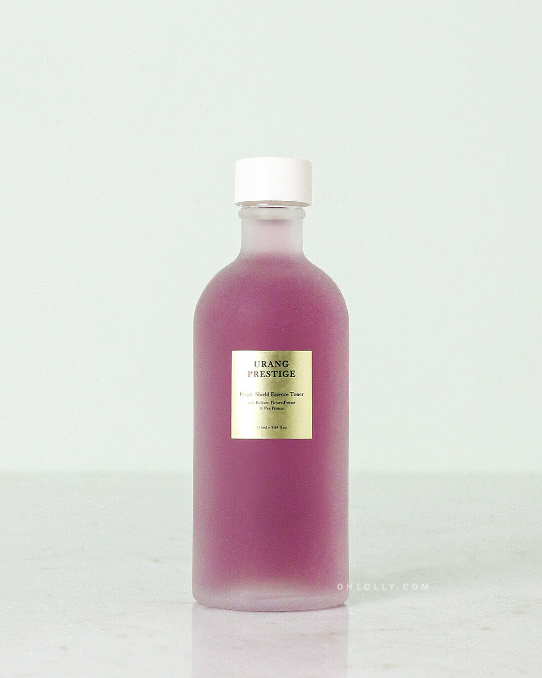 The Urang Prestige Purple Shield Essence Toner in a frosted glass bottle, showcasing the vibrant purple liquid inside, with a small gold-and-white label.