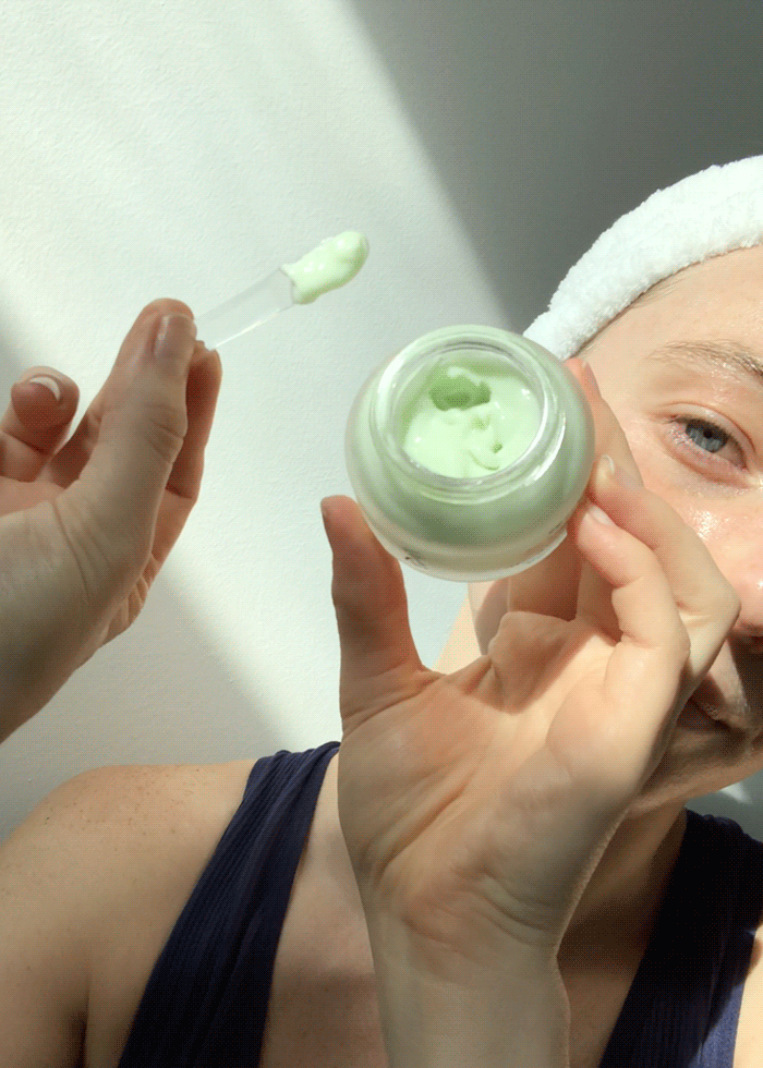 A model scooping the light green Urang Cactus Oasis Cream from the jar, demonstrating its creamy, lightweight texture for deep hydration.