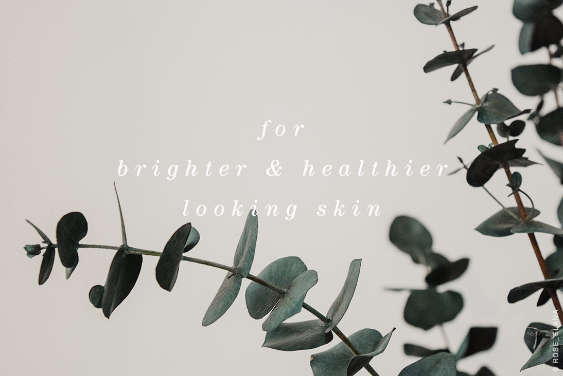 Green eucalyptus branches framing the text "for brighter & healthier looking skin" on a pale background.