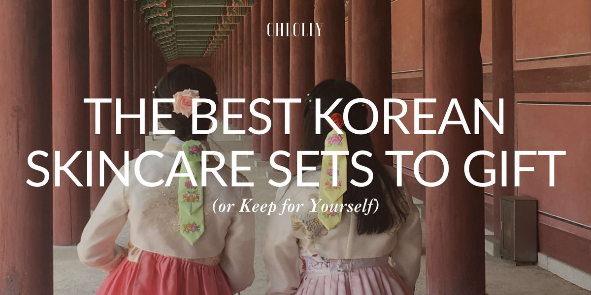 Two women in traditional Korean hanbok at a palace hallway, overlaid with text reading "The Best Korean Skincare Sets to Gift (or Keep for Yourself)".