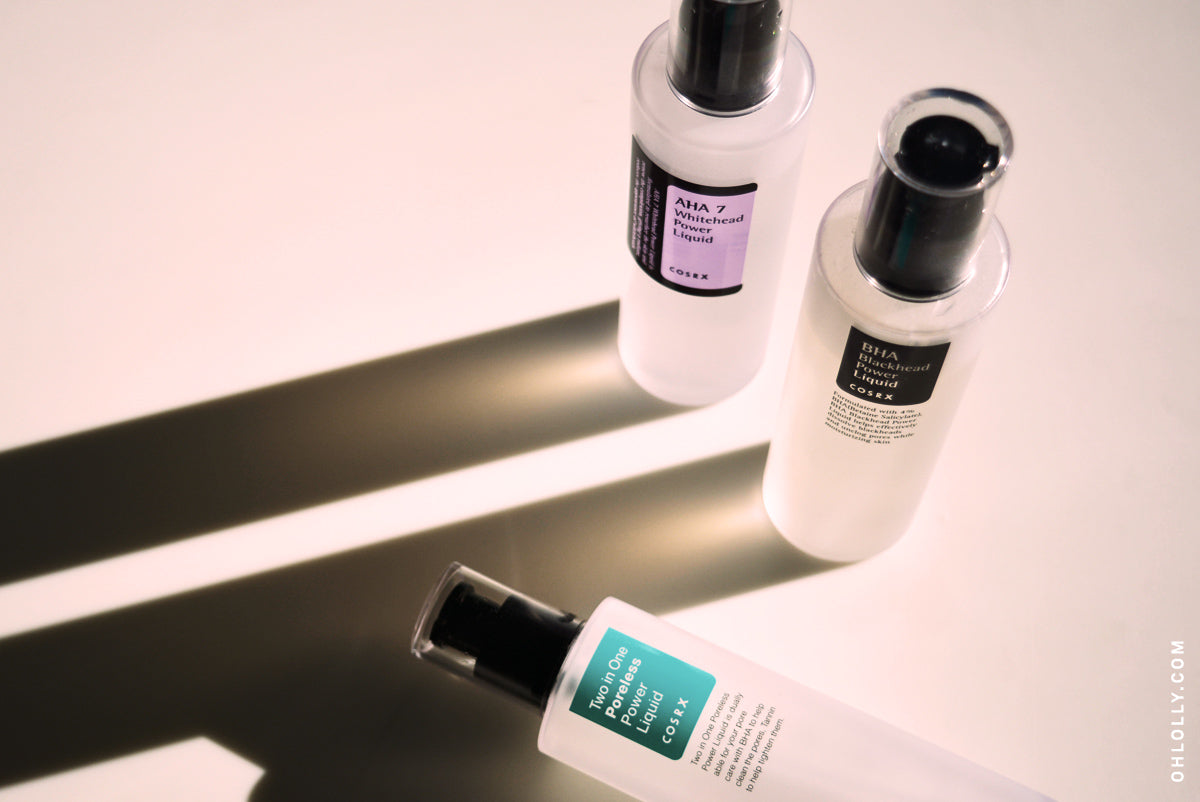 Three Cosrx acid-based skincare products on a white surface with shadows.