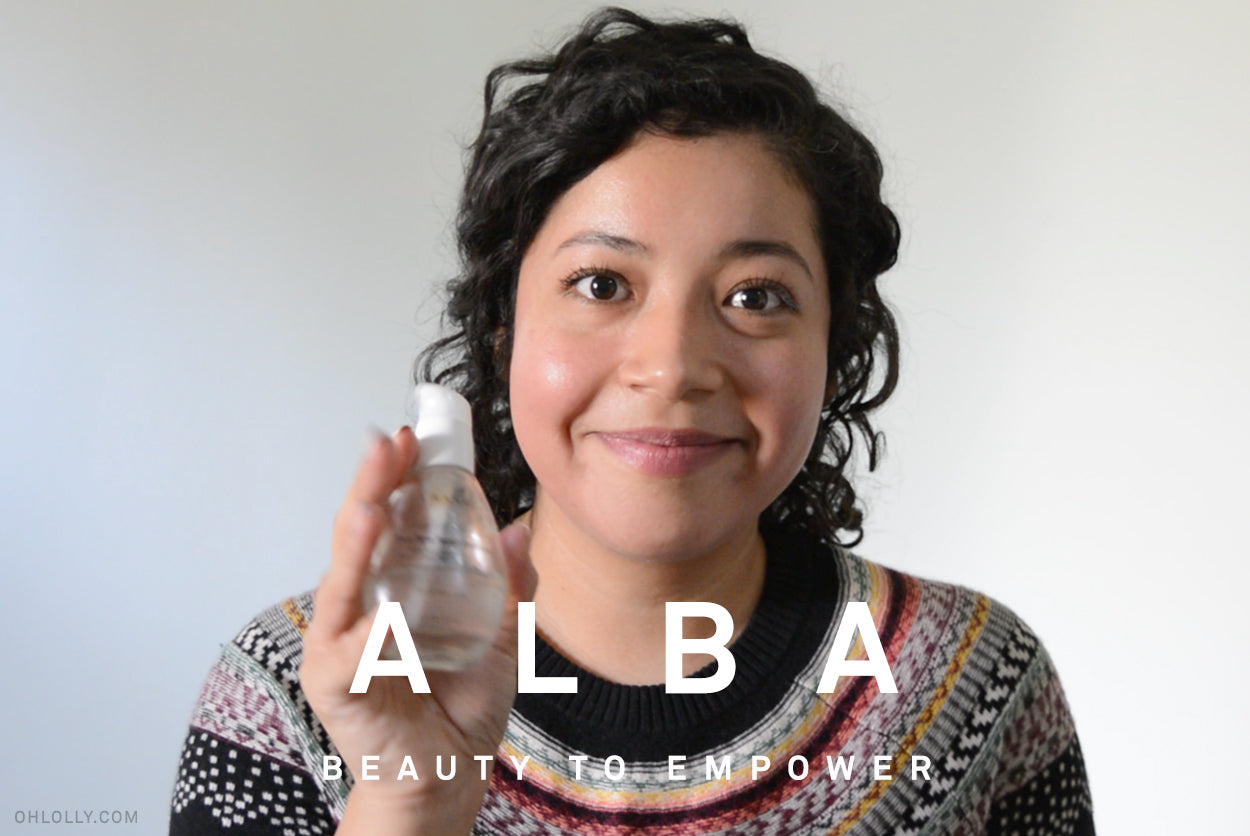 Alba presenting a bottle of beauty product. The overlay text reads: "BEAUTY TO EMPOWER."