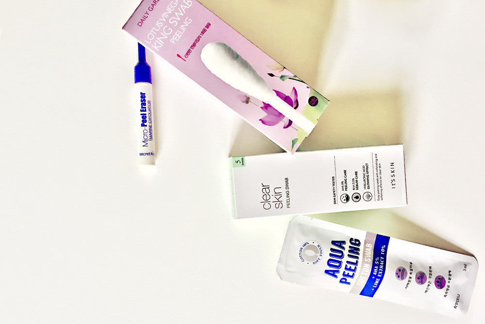 Flat lay of K-Beauty chemical exfoliators: Lotus Vinegar King Swab, Micro Peel Cleanser, and Aqua Peeling.
