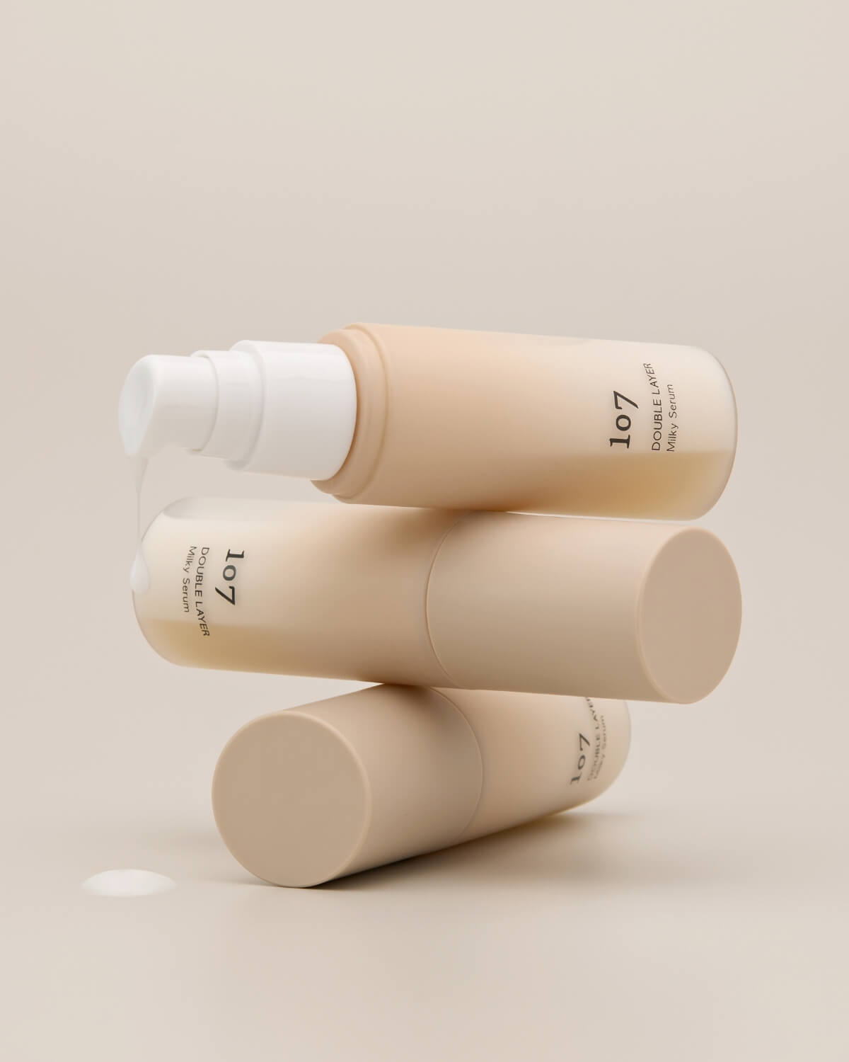 Stacked 107 Double Layer Milky Serum bottles with a drop of white milky serum.