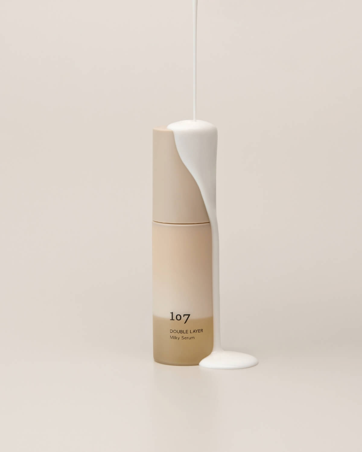Thick white milky serum coating a bottle of 107 Double Layer Milky Serum.