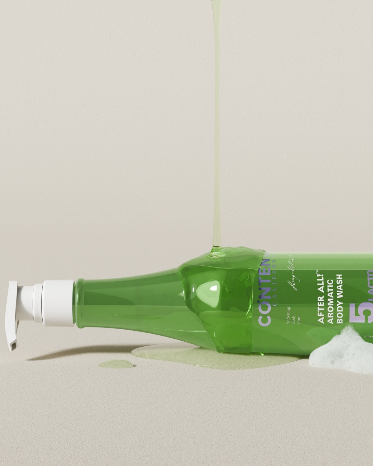 A green bottle of CONTENTLY CALIFORNIA's "After All! Aromatic Body Wash" is laid horizontally on a light beige surface. A stream of light green liquid is pouring onto the top of the bottle, and a puddle of the liquid with some foam is visible at the base of the bottle.