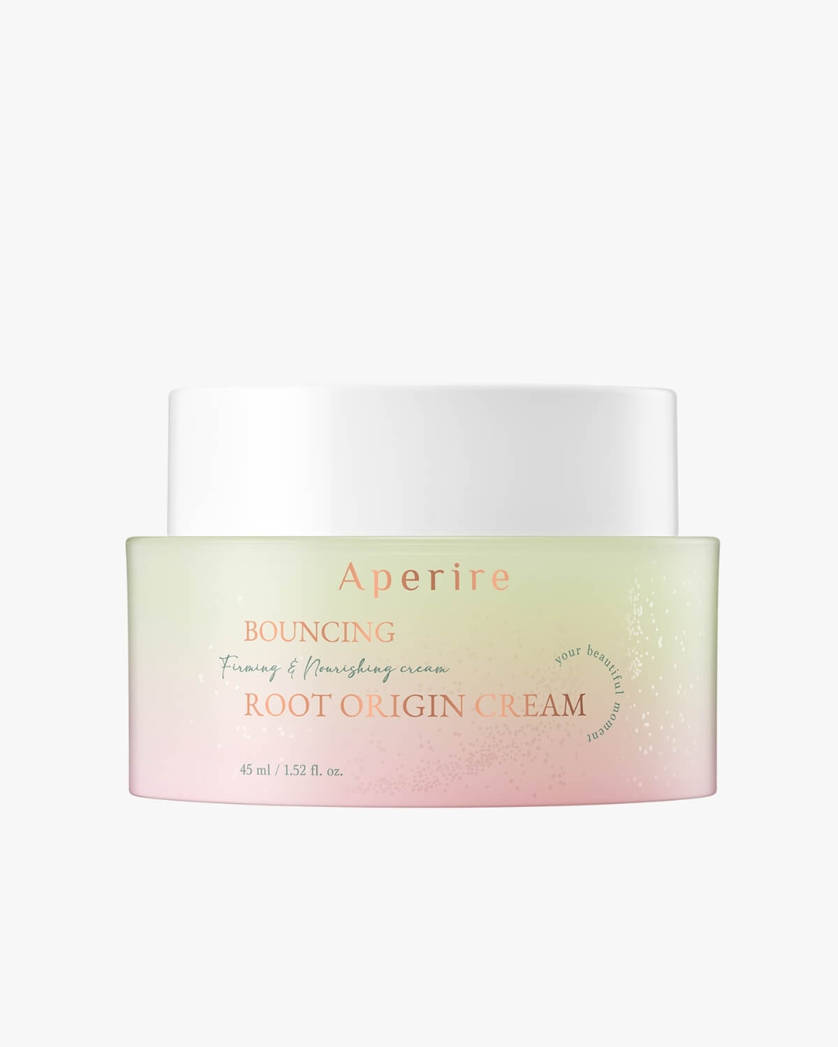 A studio close-up of the Aperire Bouncing Root Origin Cream jar. The jar features a pink and light green ombre design with a white lid. The label clearly reads "Bouncing Firming & Nourishing cream ROOT ORIGIN CREAM."