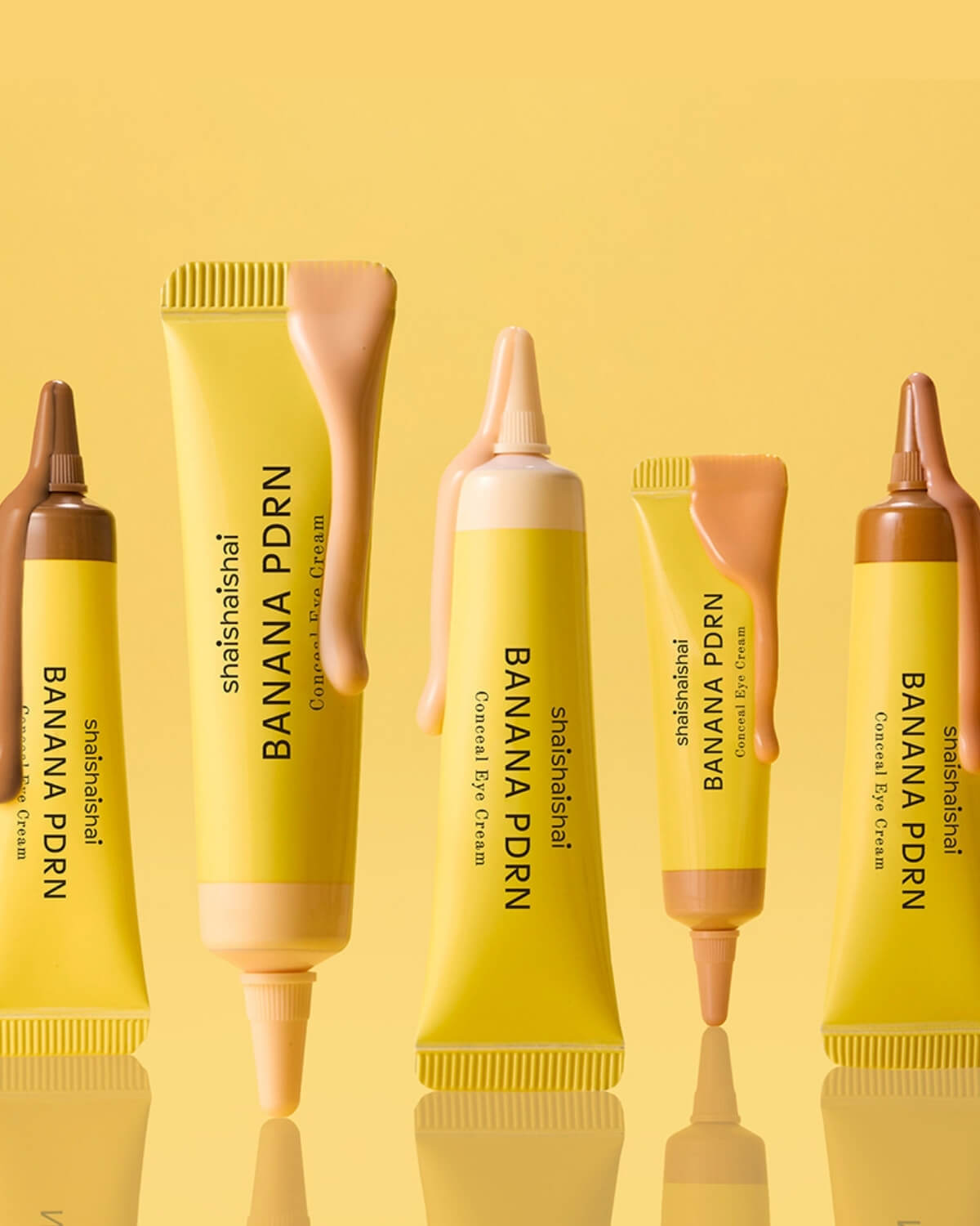 Close-up of shaishaishai Banana PDRN Conceal Eye Cream tubes with product dripping down the sides.