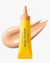 A yellow tube of shaishaishai Banana PDRN Conceal Eye Cream with a medium-light tan cream swatch in the background.