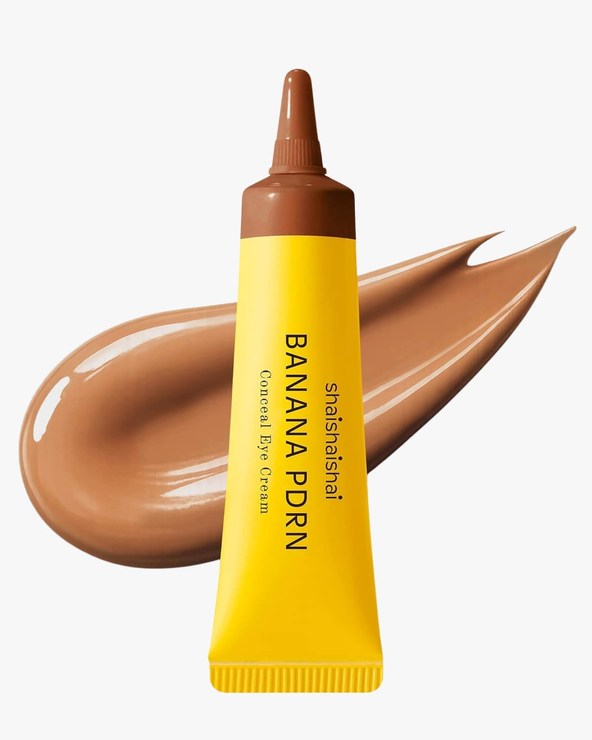 A yellow tube of shaishaishai Banana PDRN Conceal Eye Cream with a deep, rich toffee-brown cream swatch in the background.