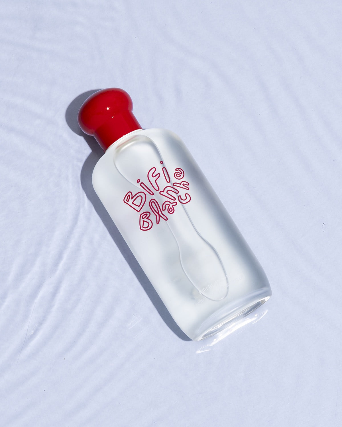 Bifi Blanche Microbiome Cleansing Oil bottle lying flat on a textured water surface.