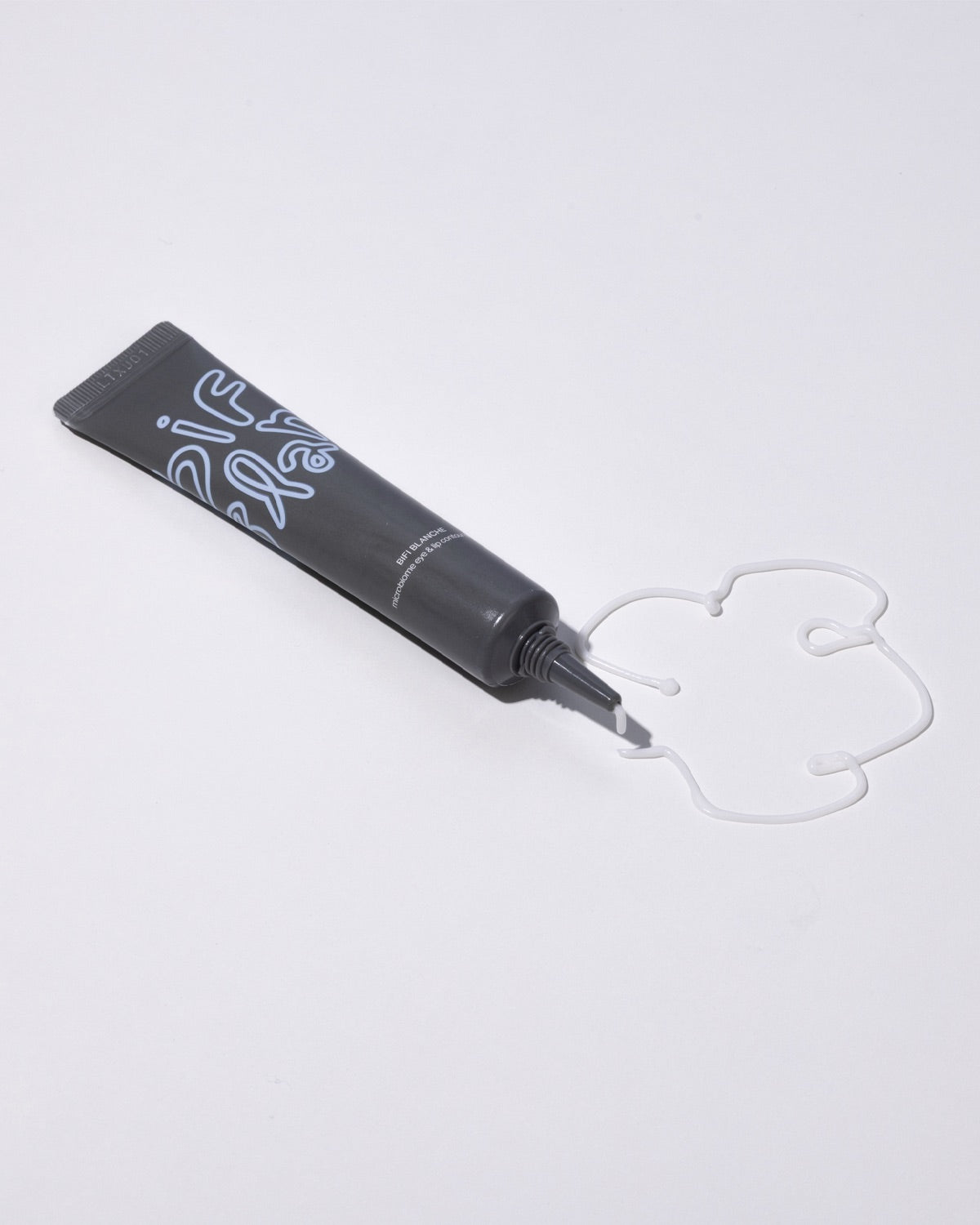 A dark gray tube of Bifi Blanche Microbiome Eye and Lip Cream next to a creative swirl of white cream texture.