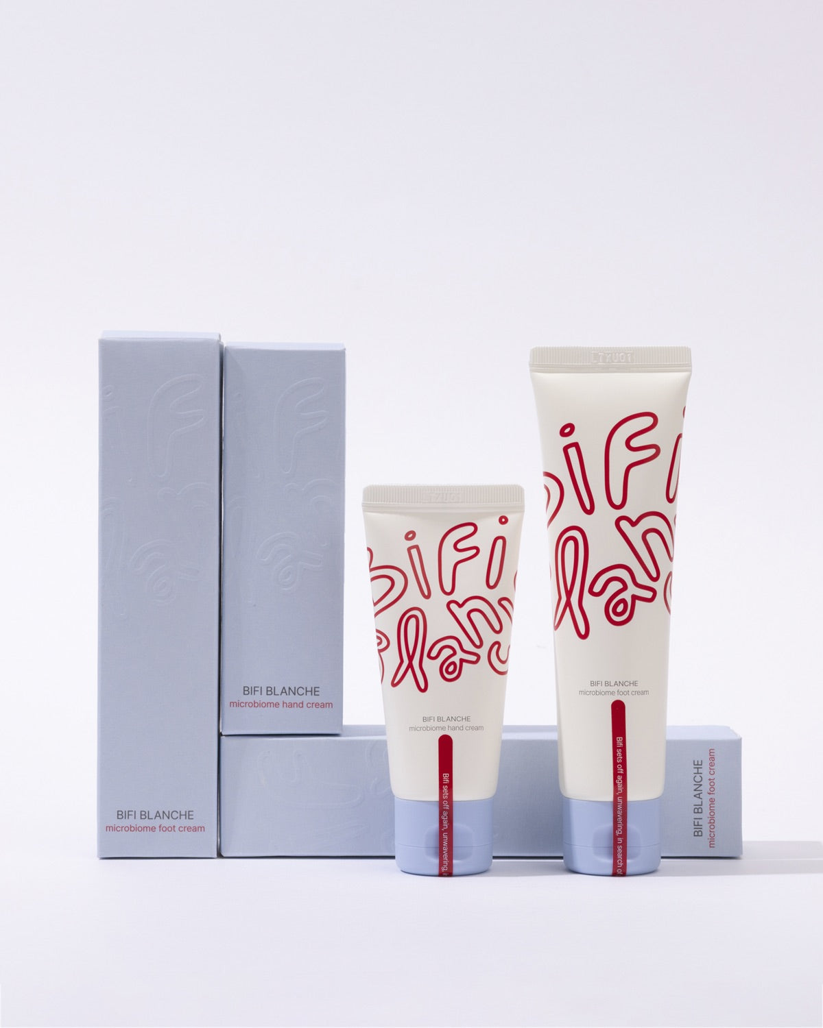 Two different sized tubes of Bifi Blanche Microbiome cream arranged with four light blue product boxes.