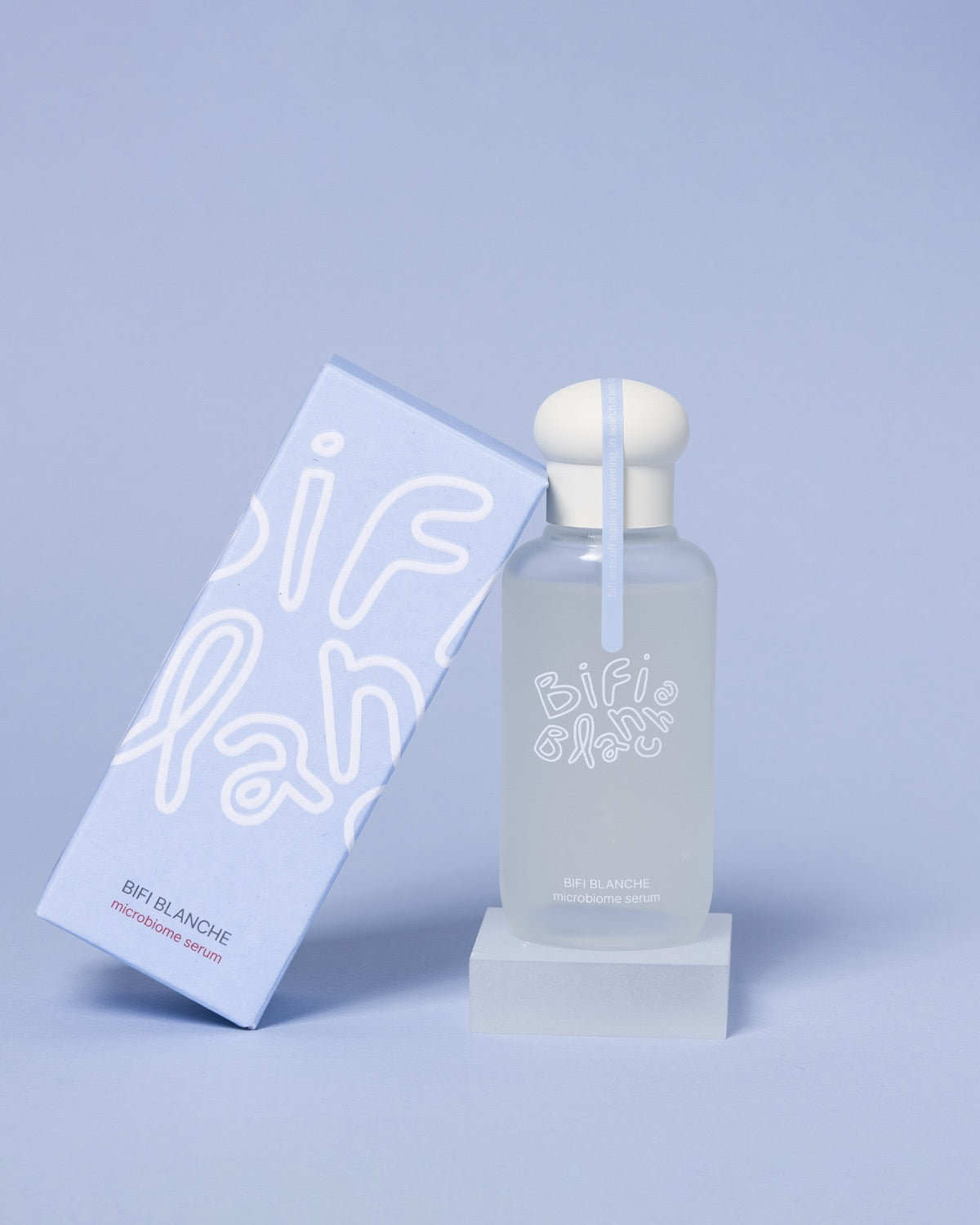 Bifi Blanche Microbiome Serum bottle on a small pedestal next to its light blue packaging box.