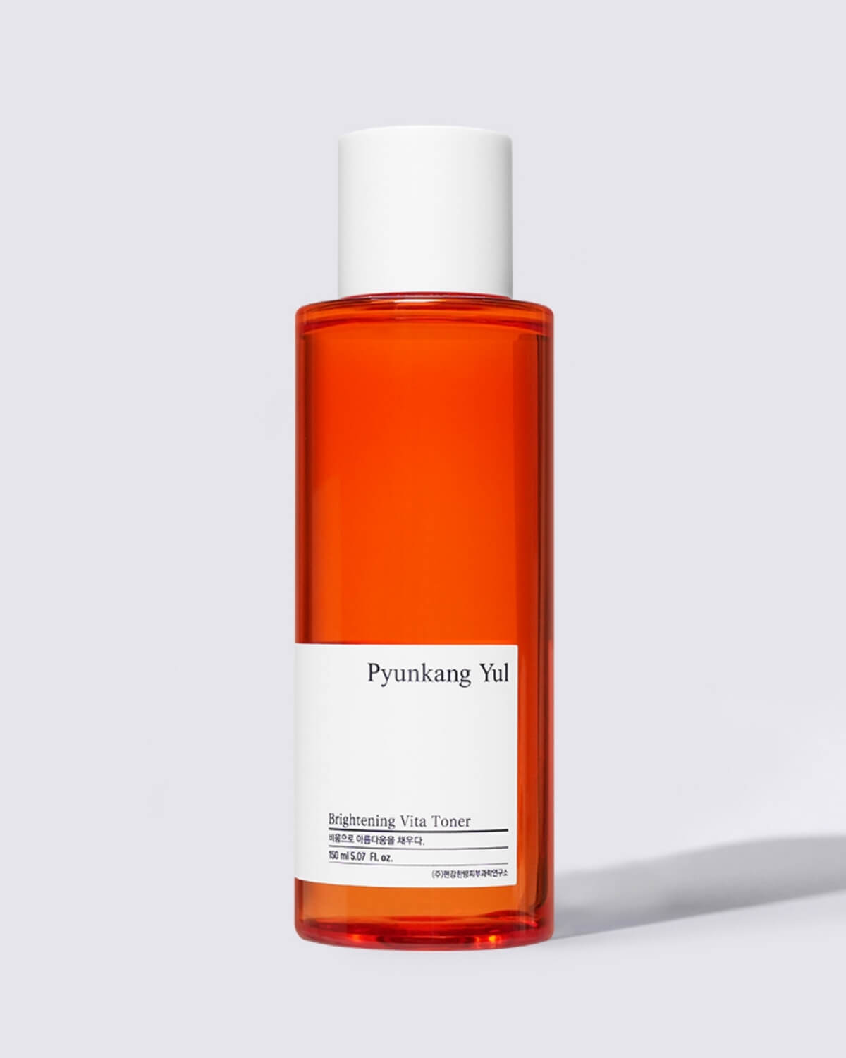 A close-up, individual shot of the tall, orange-red bottle of Pyunkang Yul Brightening Vita Toner with a white cap.