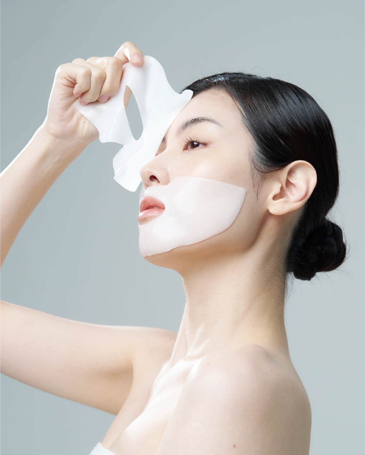 Woman applying the Equlib cooling hydrogel face mask to her chin and jawline for pore tightening and firming.