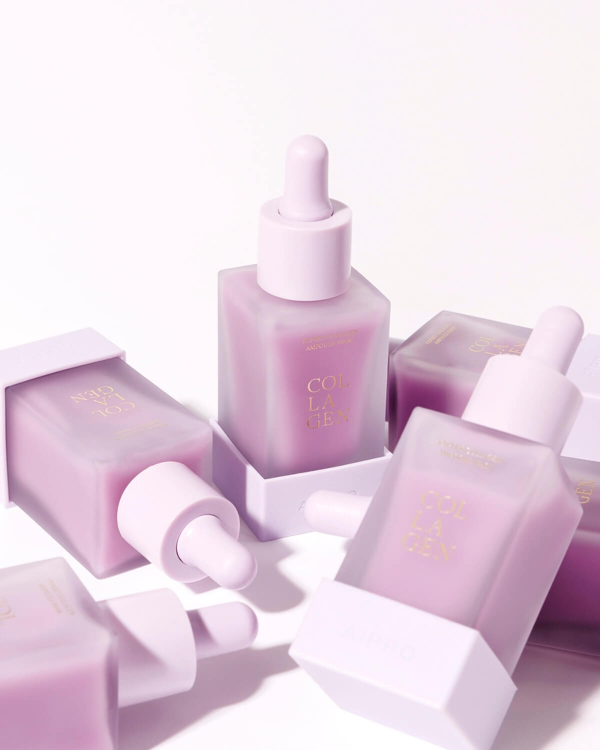 A composition of several frosted purple Aippo Collagen Ampoule Mask bottles scattered across a white surface, emphasizing the repeating pattern of the square bottles and light purple caps.