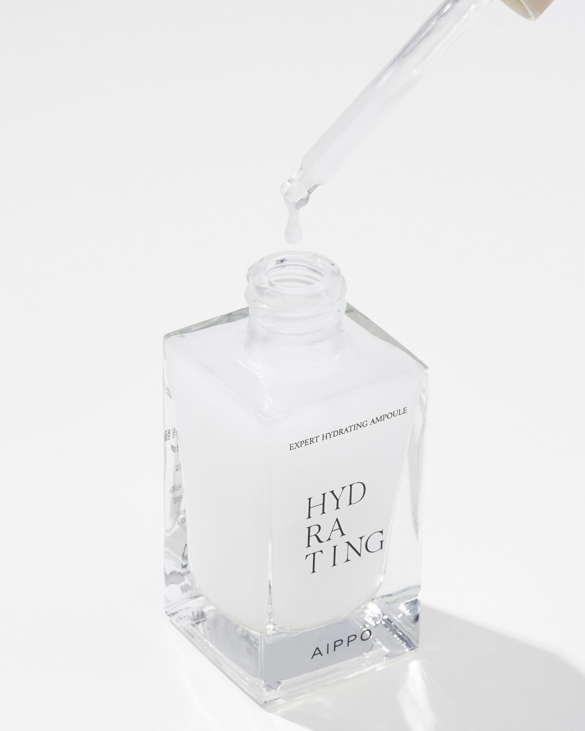 A close-up, high-angle view of a thick, curved line of the blue ampoule liquid product with a glossy texture, set against a white background.