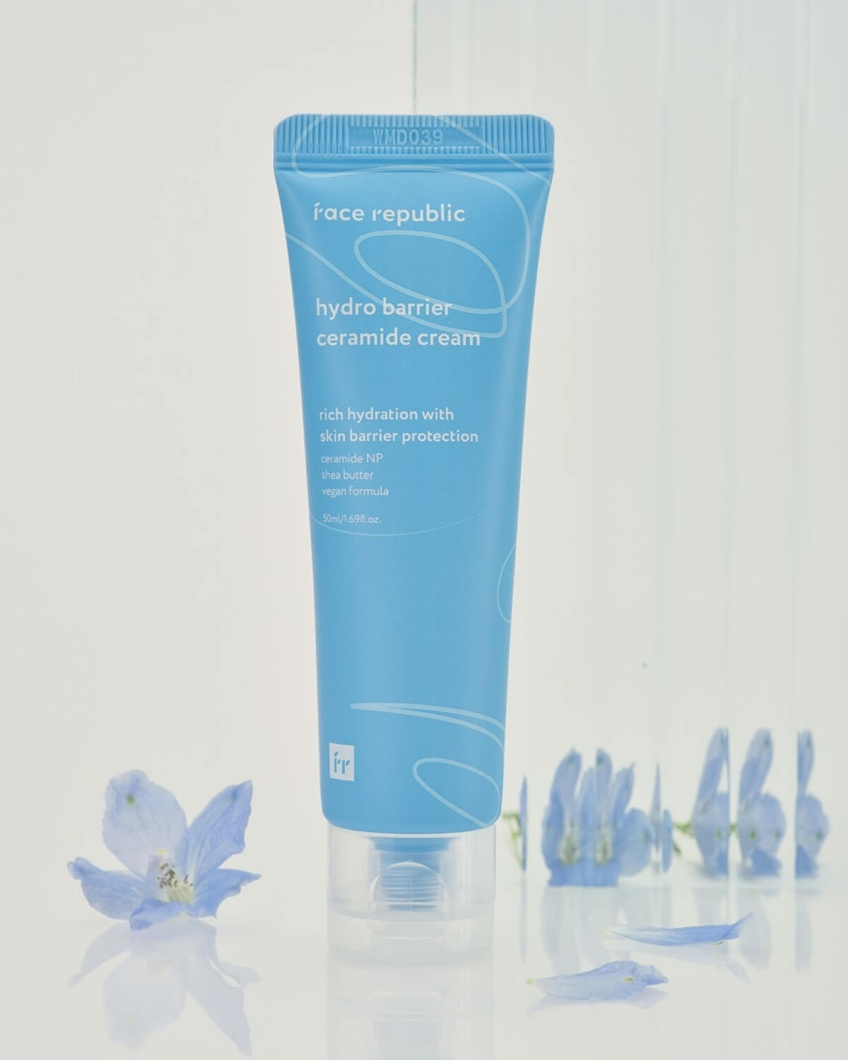 Face Republic Ceramide Cream tube standing among small blue flowers.
