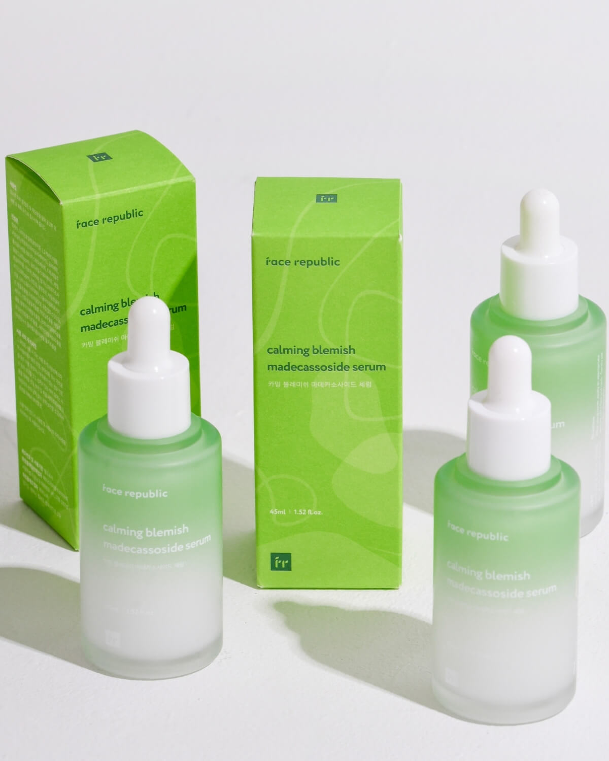 Group of Face Republic Calming Blemish Madecassoside Serum bottles and green packaging boxes.