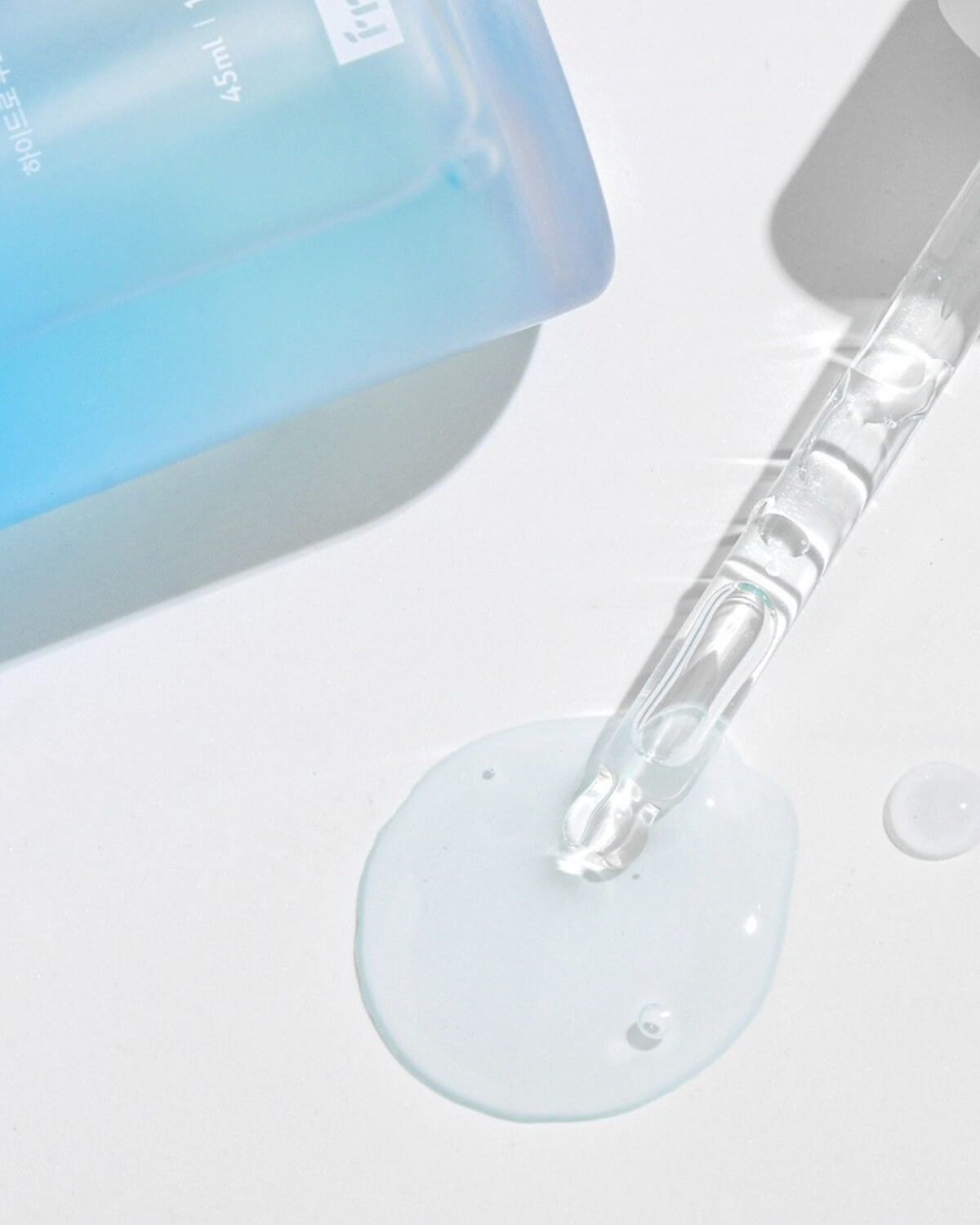 Close-up of hydrating clear serum liquid and glass dropper.