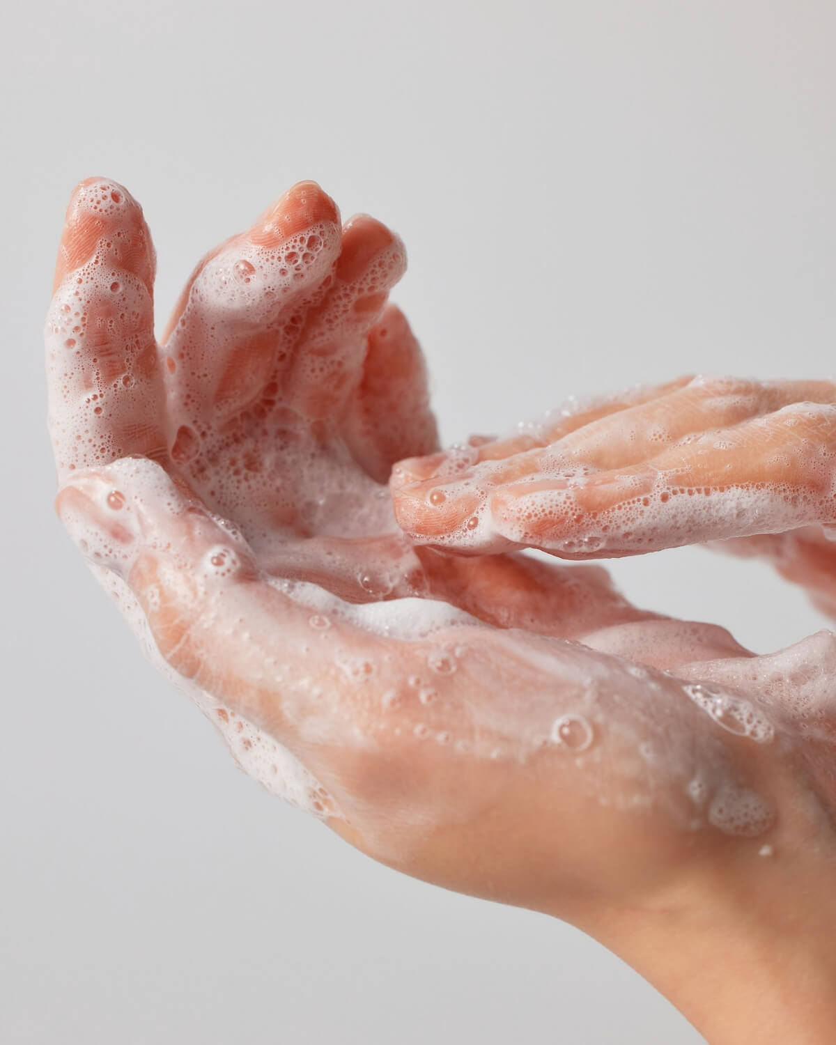 Close-up of hands lathering Face Republic Hydro Derma Gentle Cleanser into a rich, silky foam.