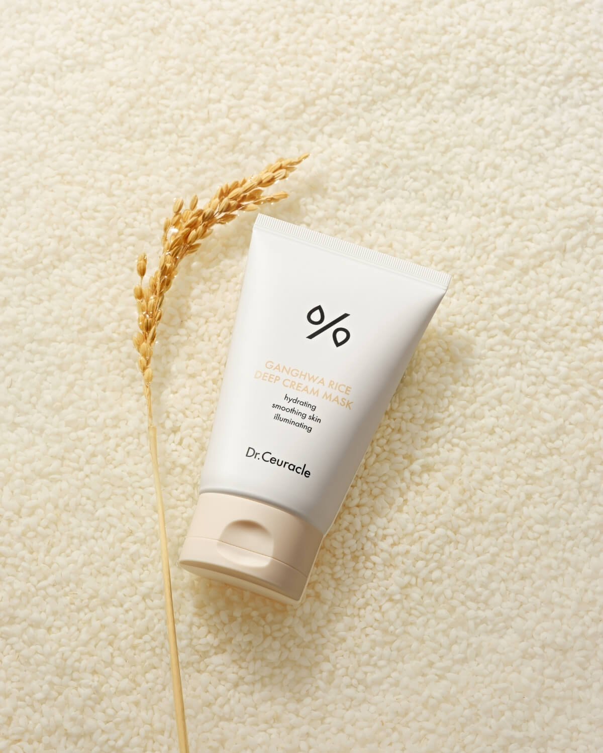 Flat lay of Dr. Ceuracle Ganghwa Rice Deep Cream Mask sitting on a bed of raw white rice grains.