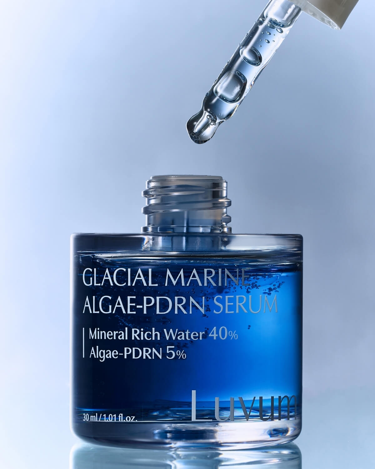 Close-up of Luvum Glacial Marine Algae-PDRN Serum bottle with a glass dropper hovering above.