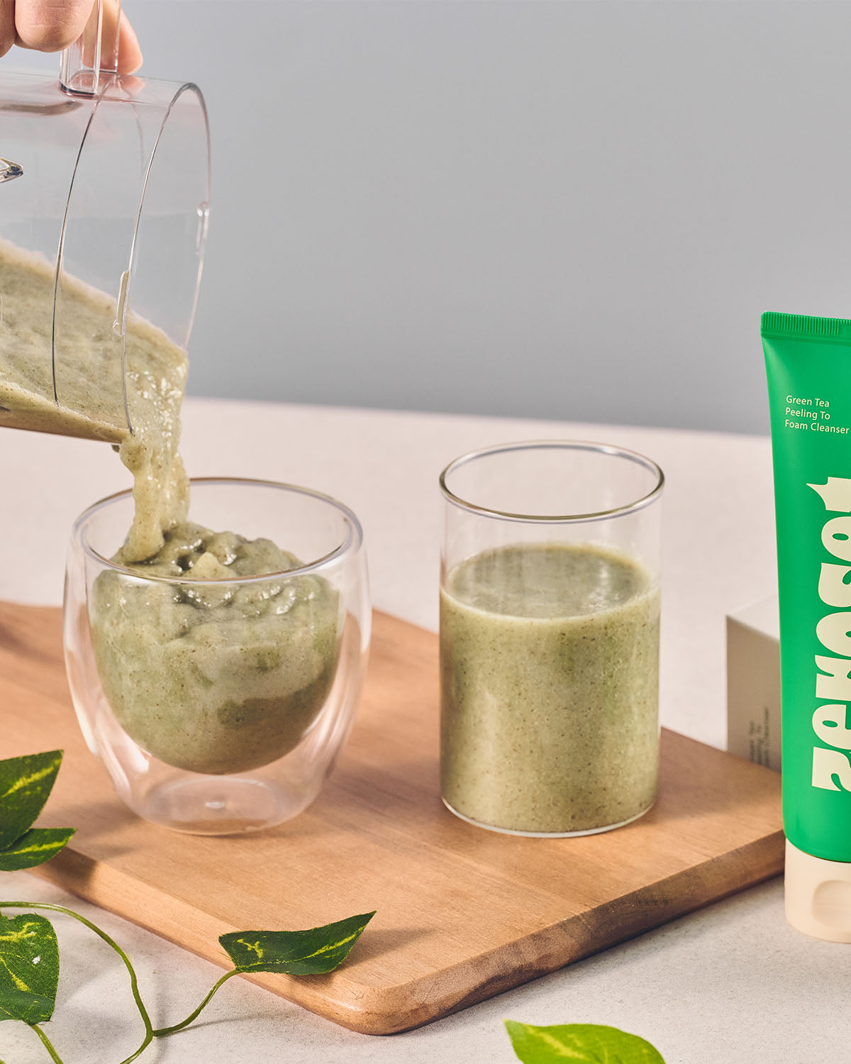 Blended green tea gel cleanser being poured into a glass next to the Zeroset cleanser tube.