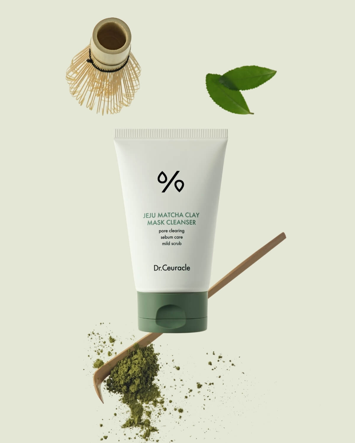 Dr. Ceuracle Jeju Matcha Clay Mask Cleanser tube surrounded by matcha powder, scoop, and whisk.
