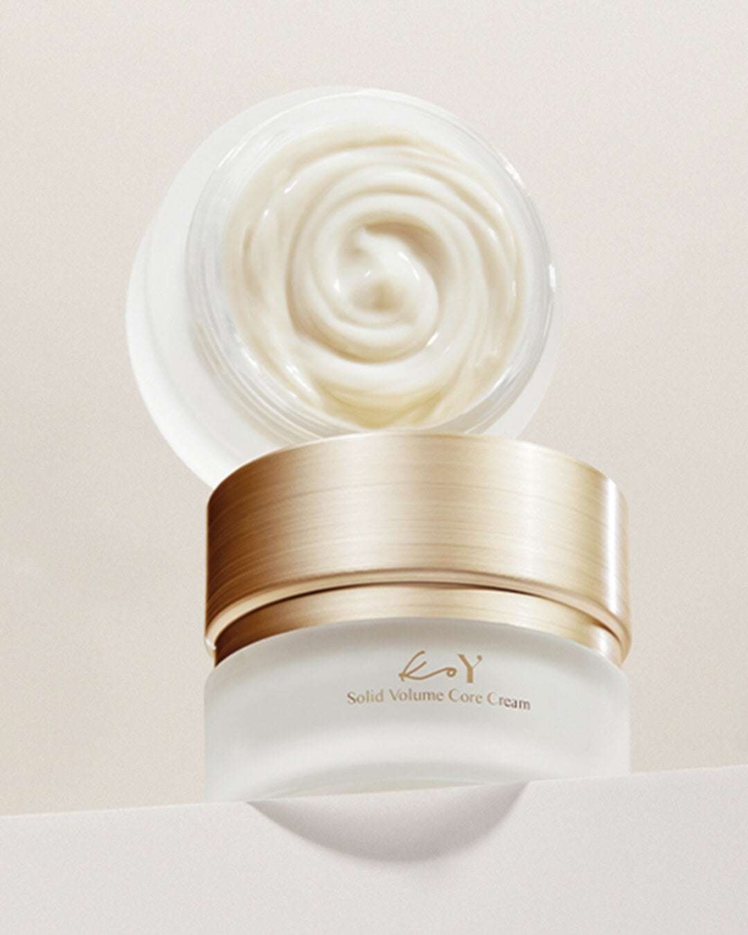 Two jars of Koy Solid Volume Core Cream, one open showing the rich white moisturizer texture, stacked elegantly.