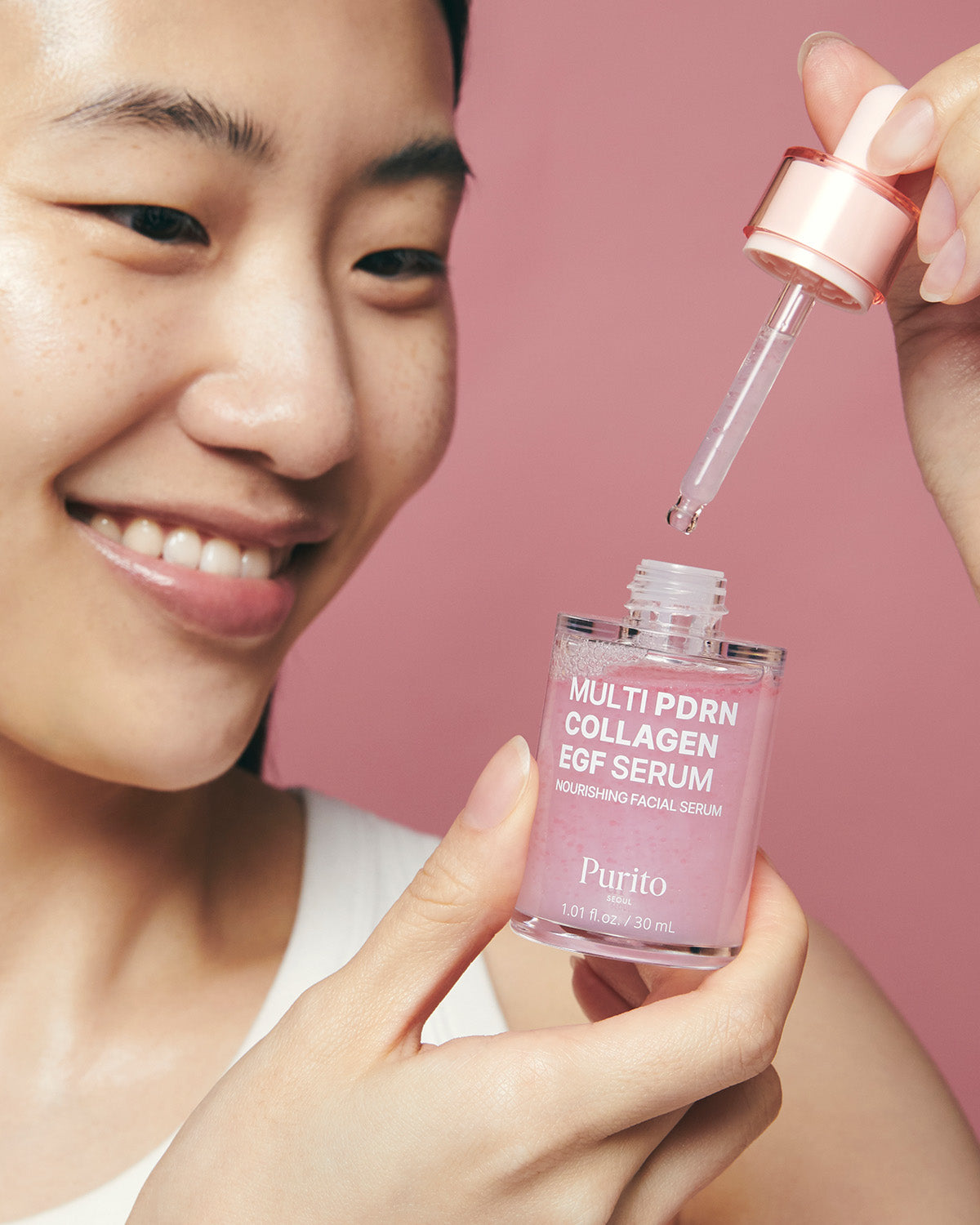 A woman holding an open bottle of Purito Multi PDRN Collagen EGF Serum and a glass dropper.