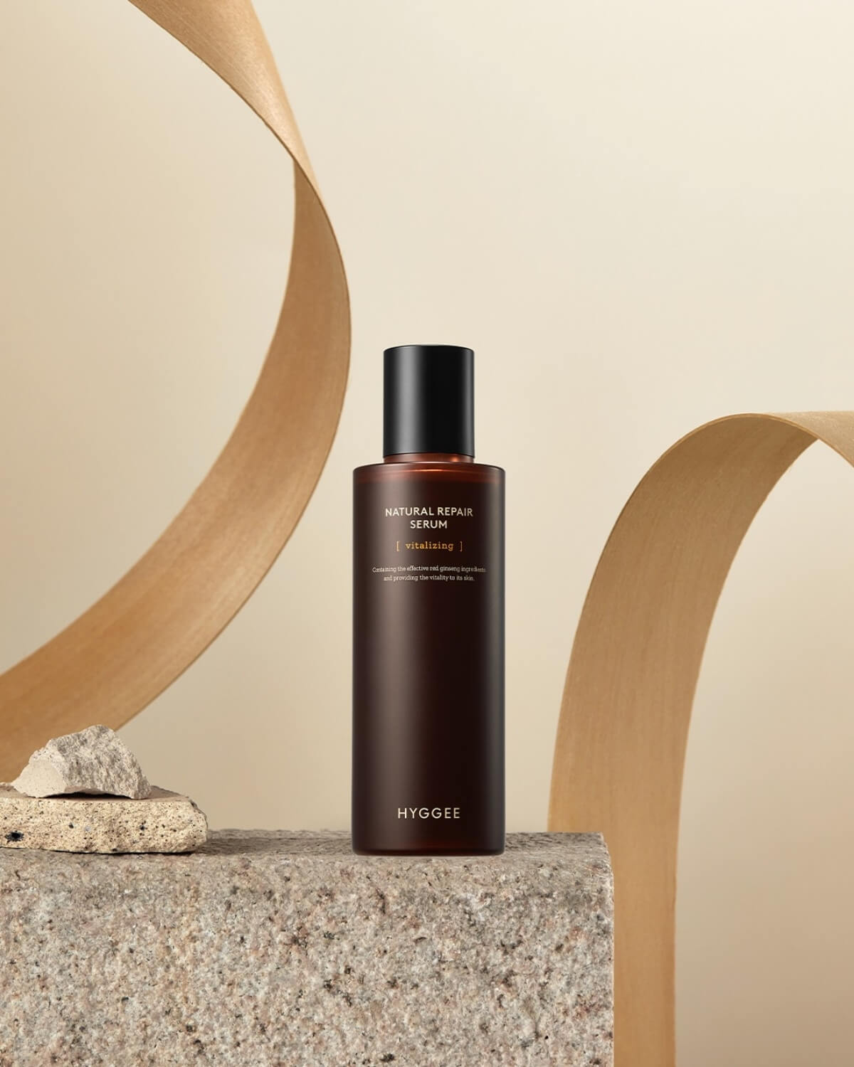 Hyggee Natural Repair Serum (Vitalizing), a red ginseng-based skincare product for skin vitality, on a stone podium.